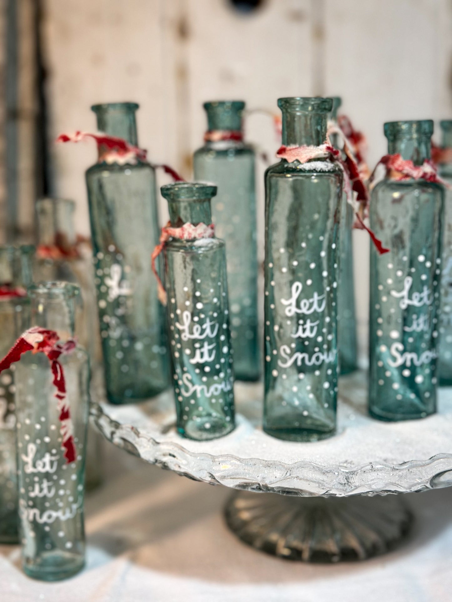 A beautiful Victorian cylinder bottle painted with a Christmas quote “Let it Snow”