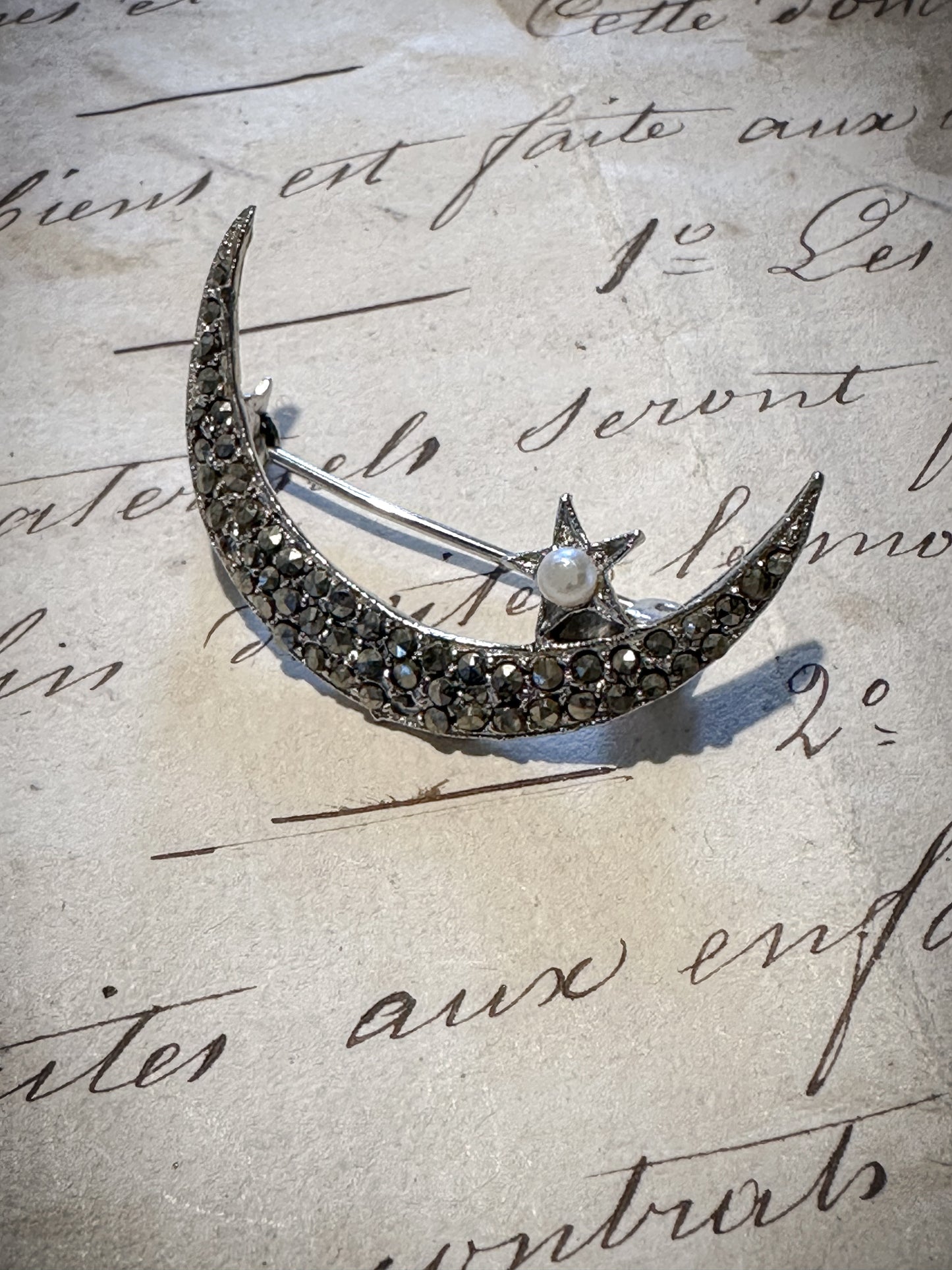 A stunning vintage marcasite and seed pearl crescent brooch