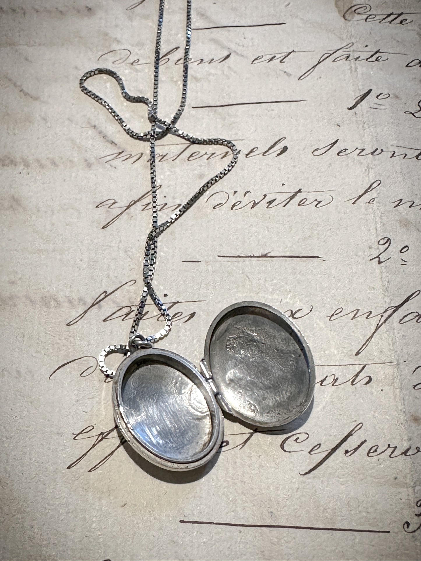 A pretty oval sterling silver vintage locket and chain