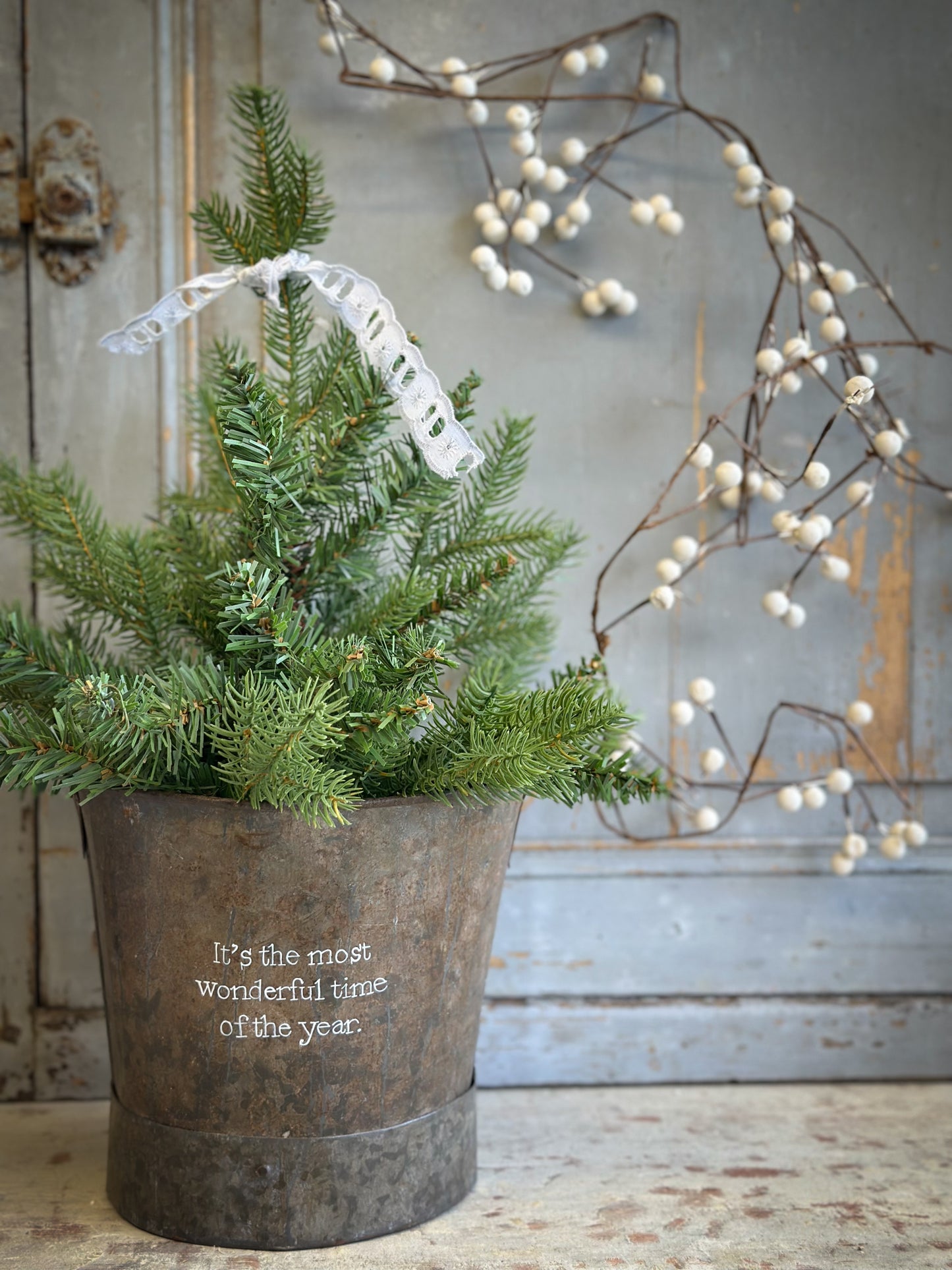 A Recycled Metal Small Christmas Tree Bucket With A Hand Painted Quote