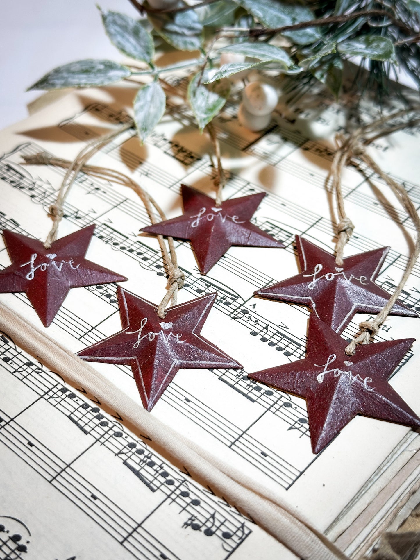 A mini tin barn star red decoration hand painted with “Love”