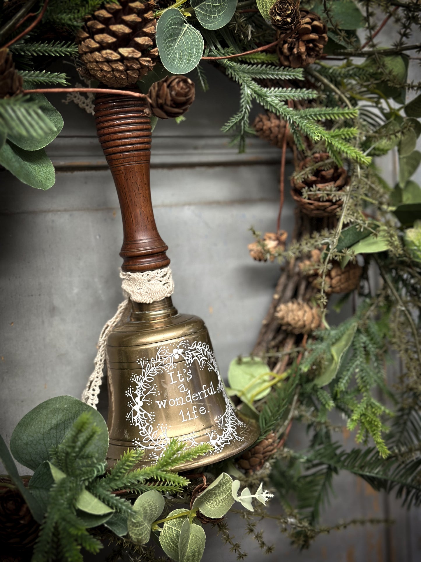 A vintage brass hand held bell with a hand painted quote