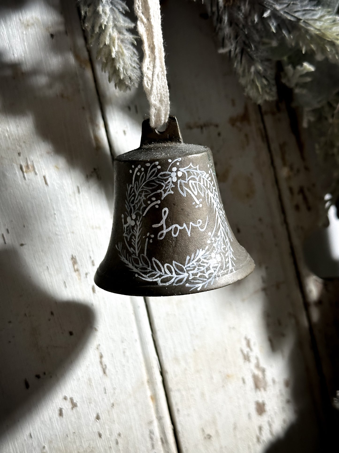 A vintage brass bell with a hand painted quote