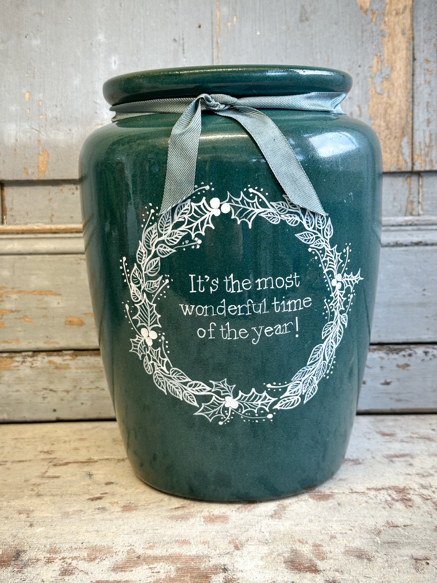 A large Emerald Green Antique Creamery Vase Bottle with a Hand Painted Wreath and Christmas Quote
