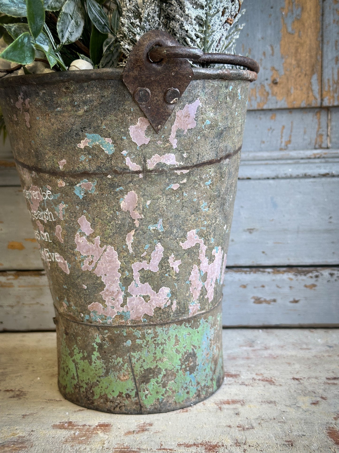 A Recycled Metal Mini Christmas Tree Bucket With A Hand Painted Quote