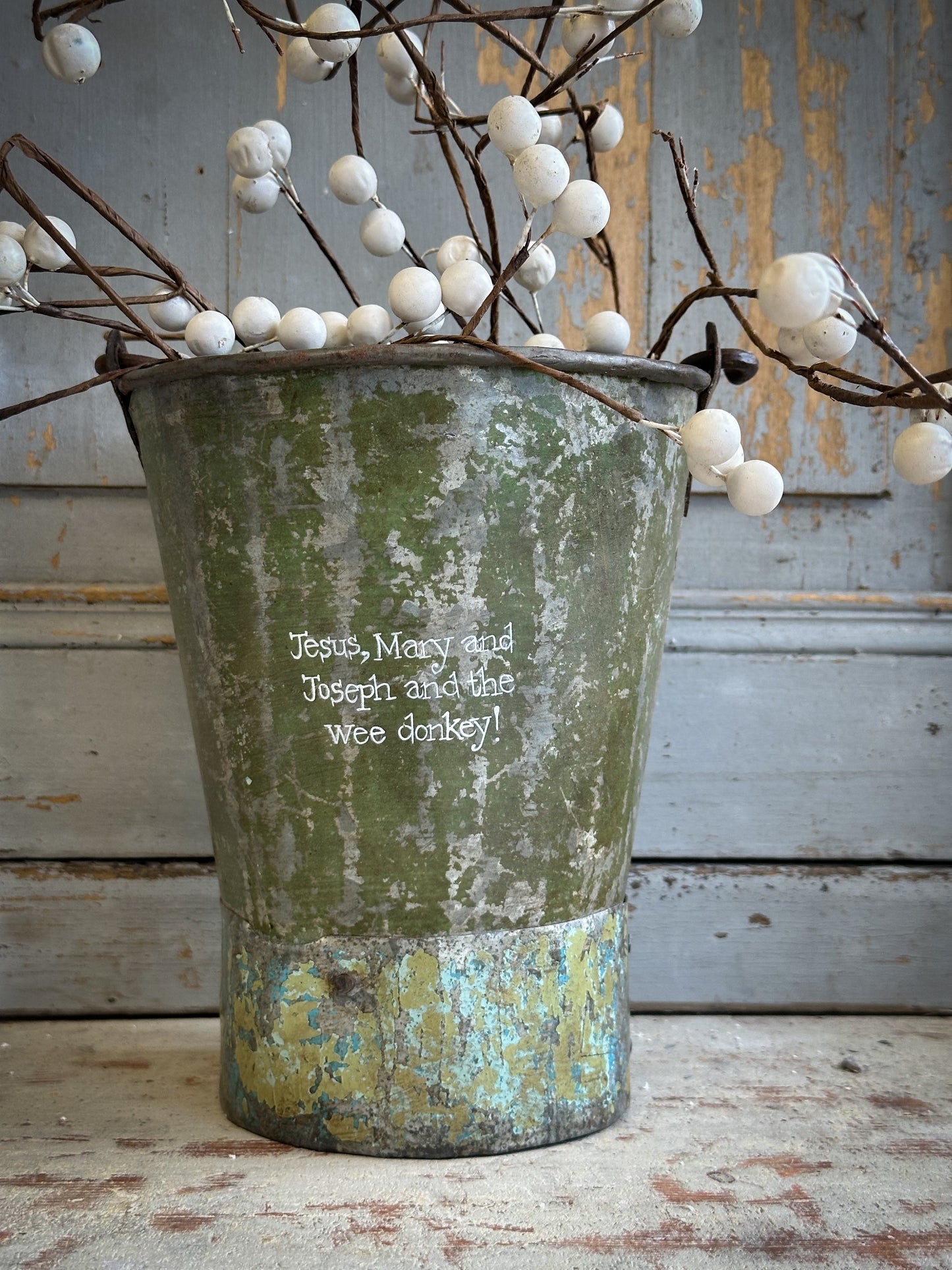 A Recycled Metal Mini Christmas Tree Bucket With A Hand Painted Quote