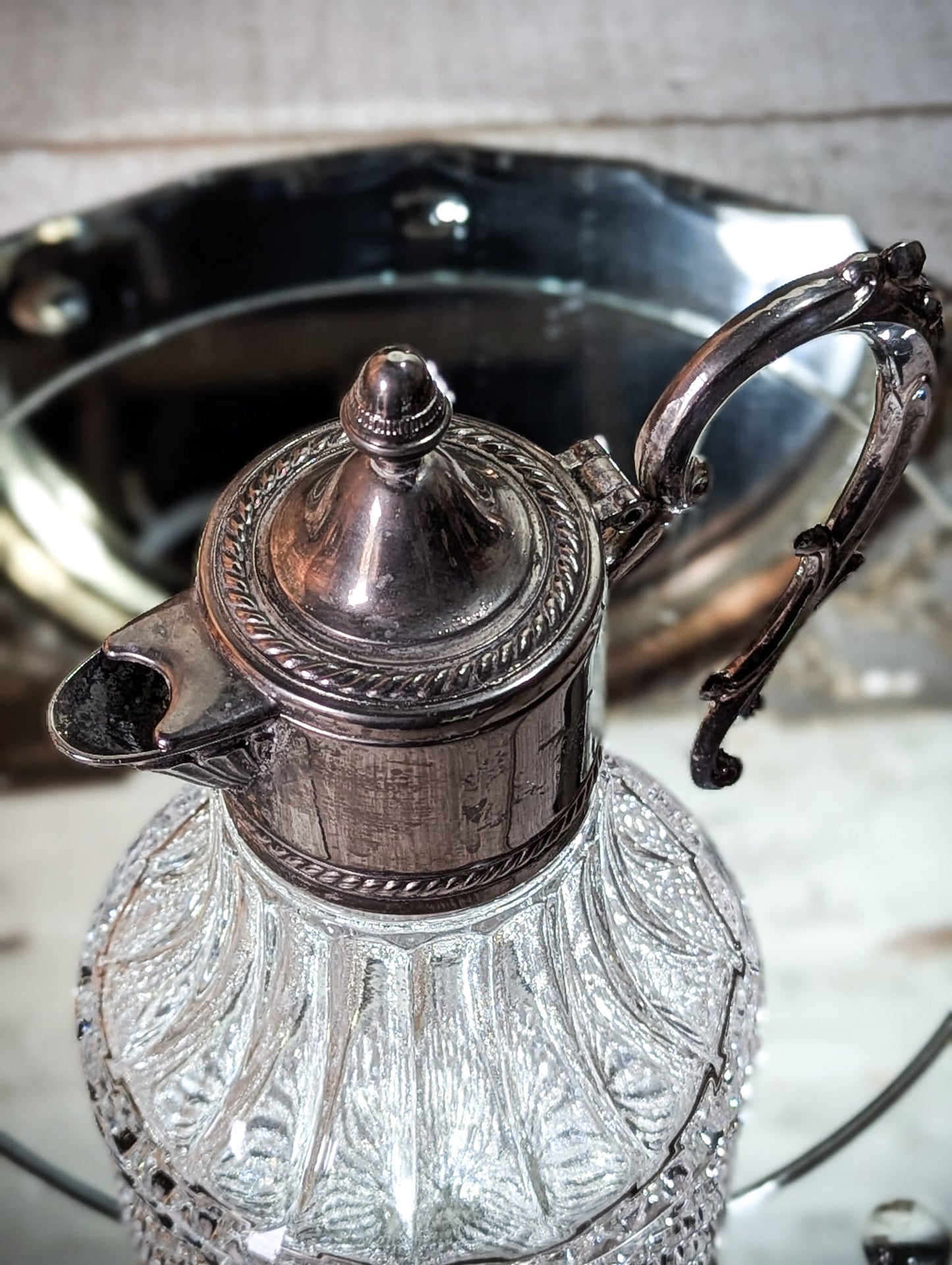 A vintage pressed glass silver plated wine jug