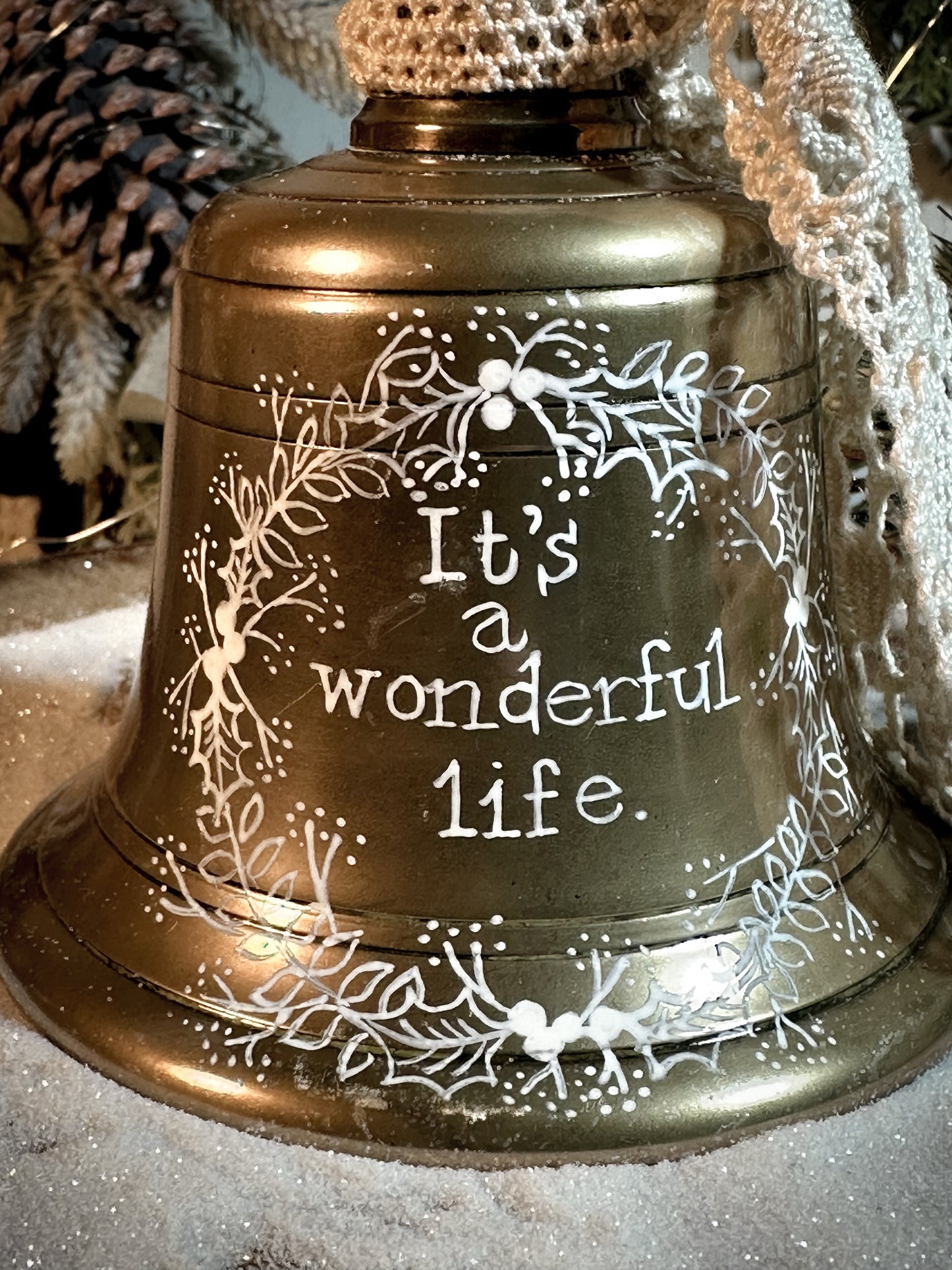 A vintage brass hand held bell with a hand painted quote