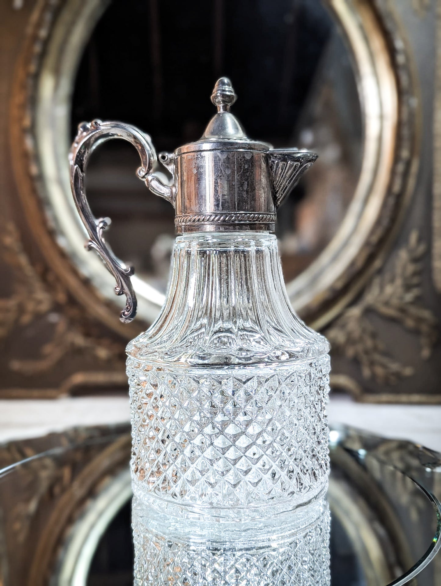 A vintage pressed glass silver plated wine jug