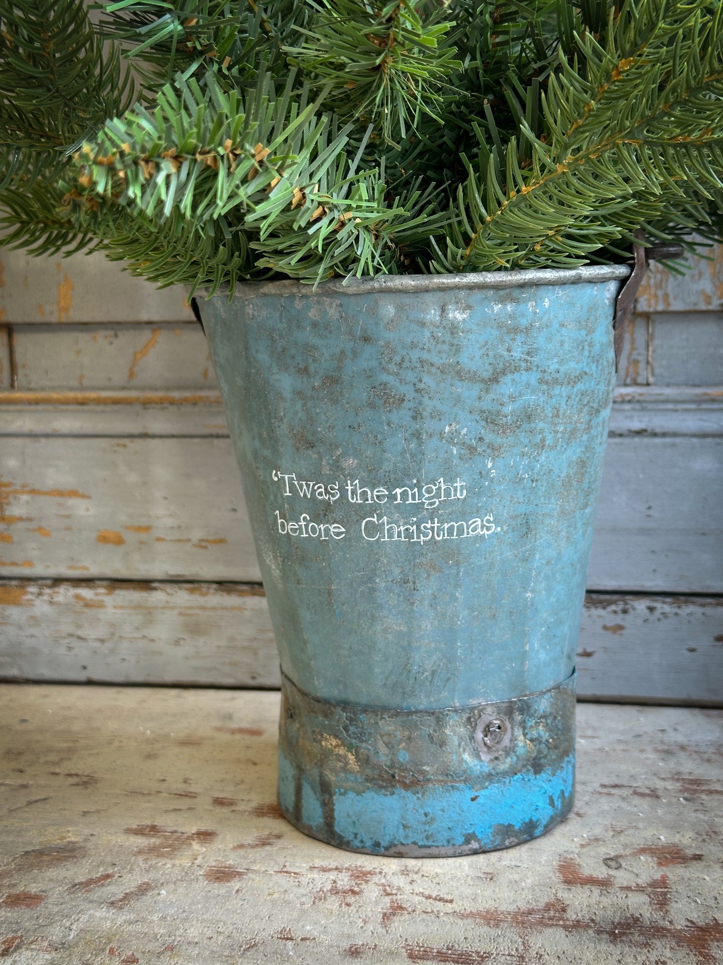 A Recycled Metal Mini Christmas Tree Bucket With A Hand Painted Quote