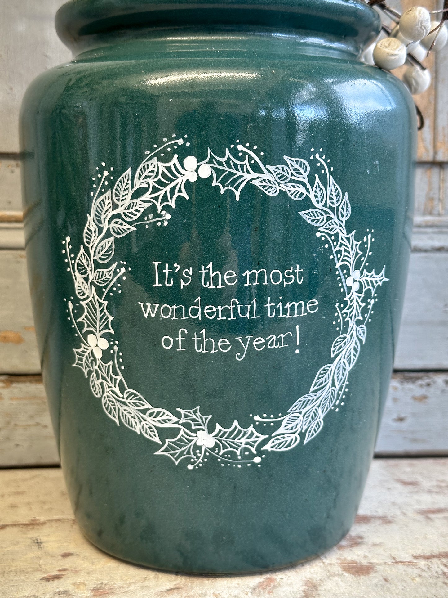A large Emerald Green Antique Creamery Vase Bottle with a Hand Painted Wreath and Christmas Quote