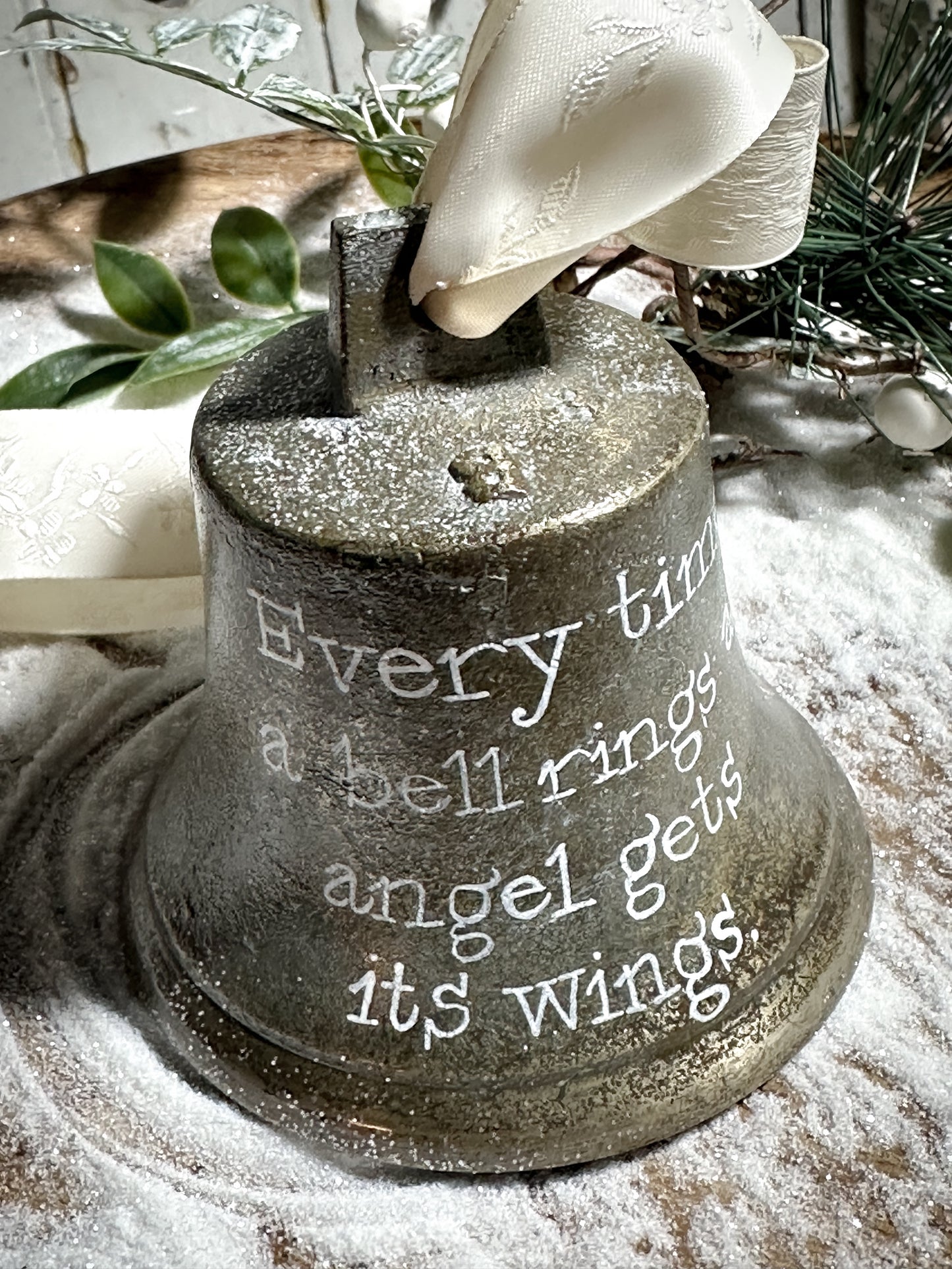 A vintage brass bell with a hand painted quote