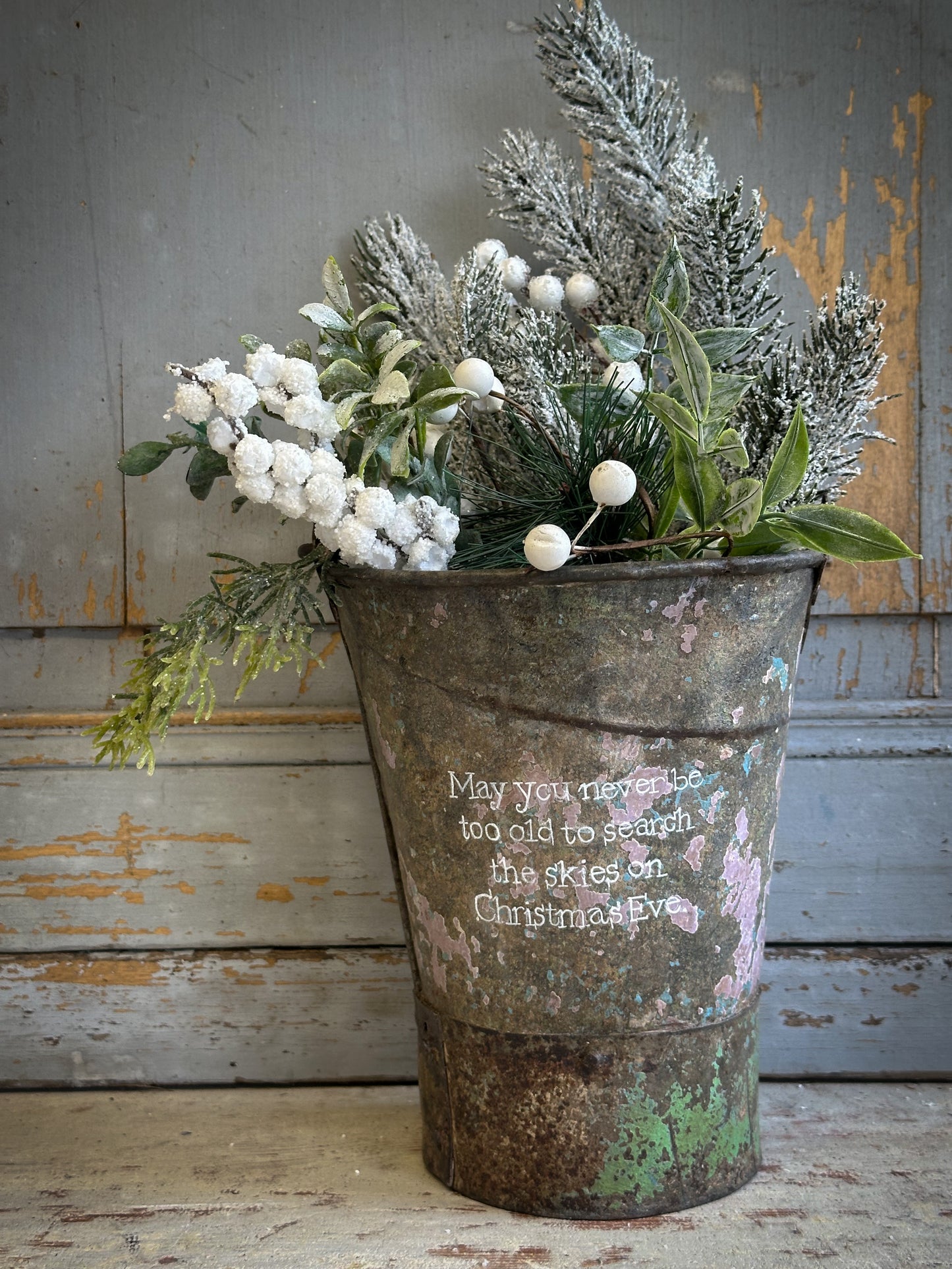 A Recycled Metal Mini Christmas Tree Bucket With A Hand Painted Quote