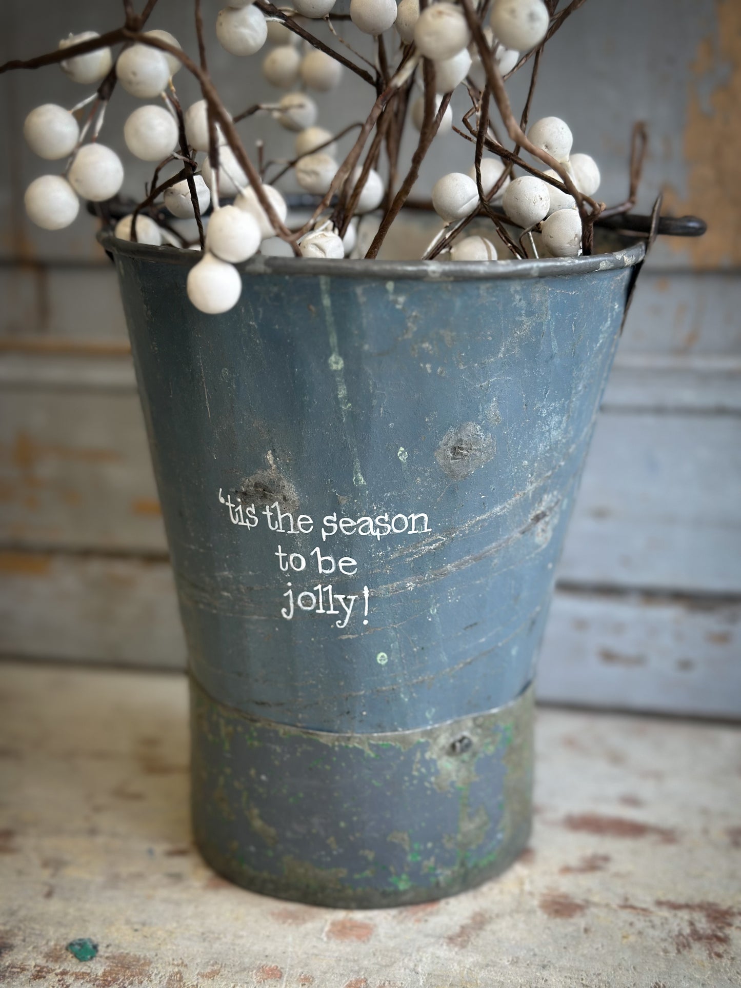 A Recycled Metal Mini Christmas Tree Bucket With A Hand Painted Quote