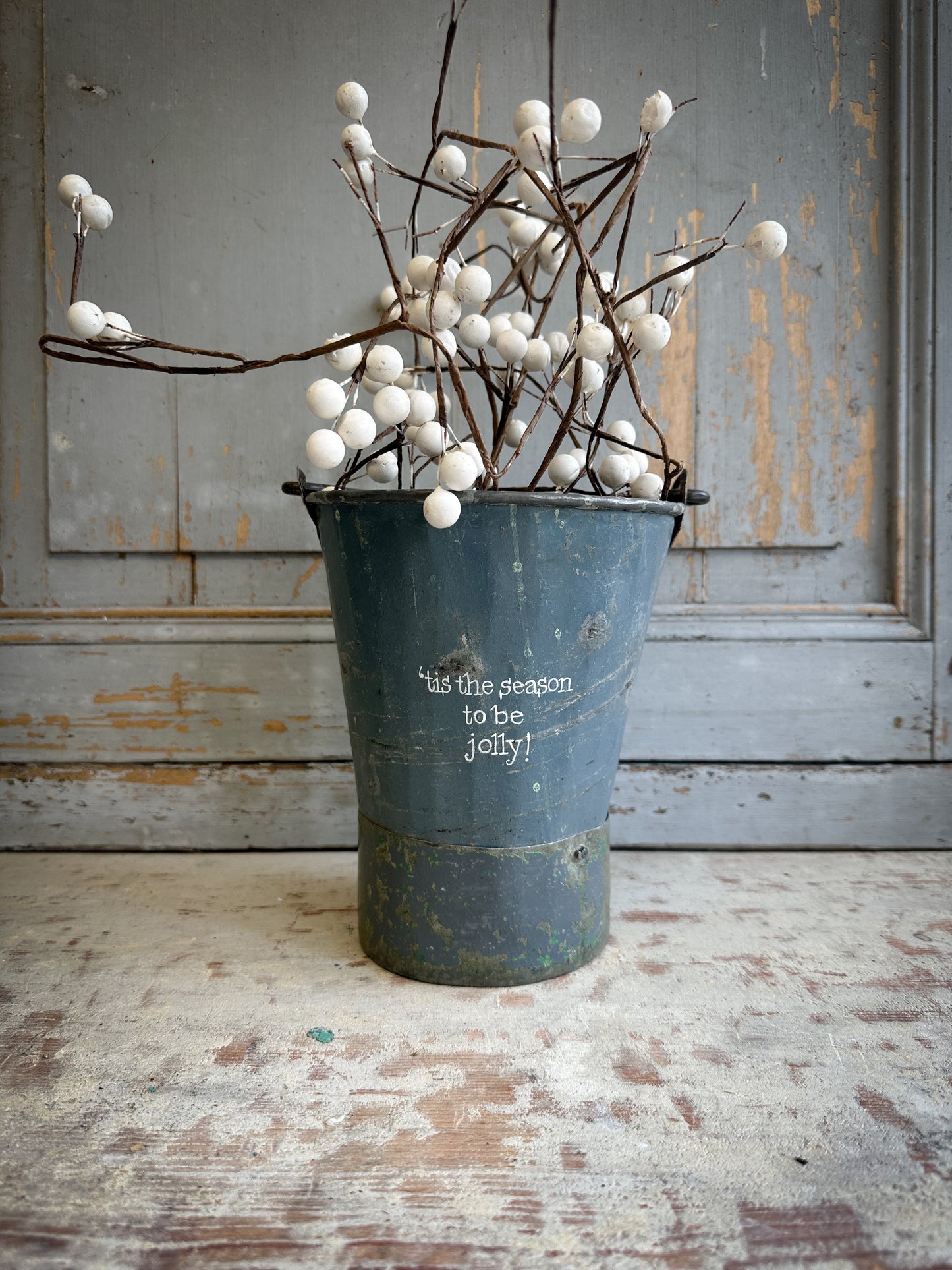 A Recycled Metal Mini Christmas Tree Bucket With A Hand Painted Quote