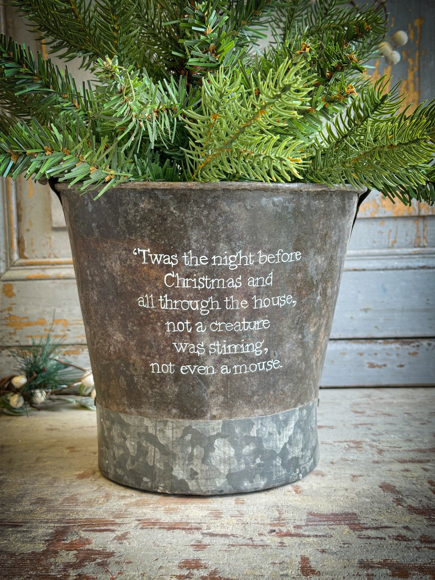 A Recycled Metal Small Christmas Tree Bucket With A Hand Painted Quote