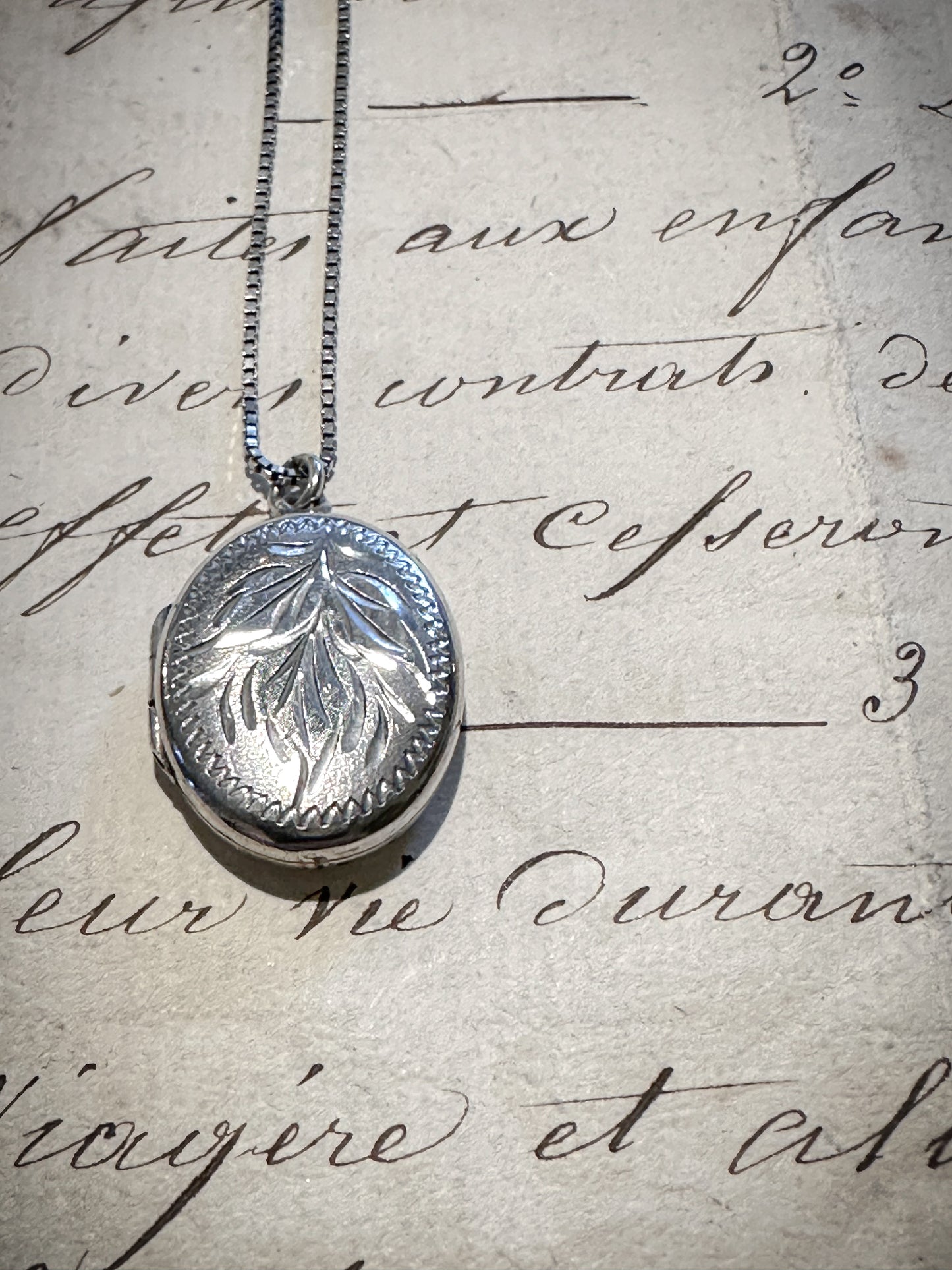 A pretty oval sterling silver vintage locket and chain