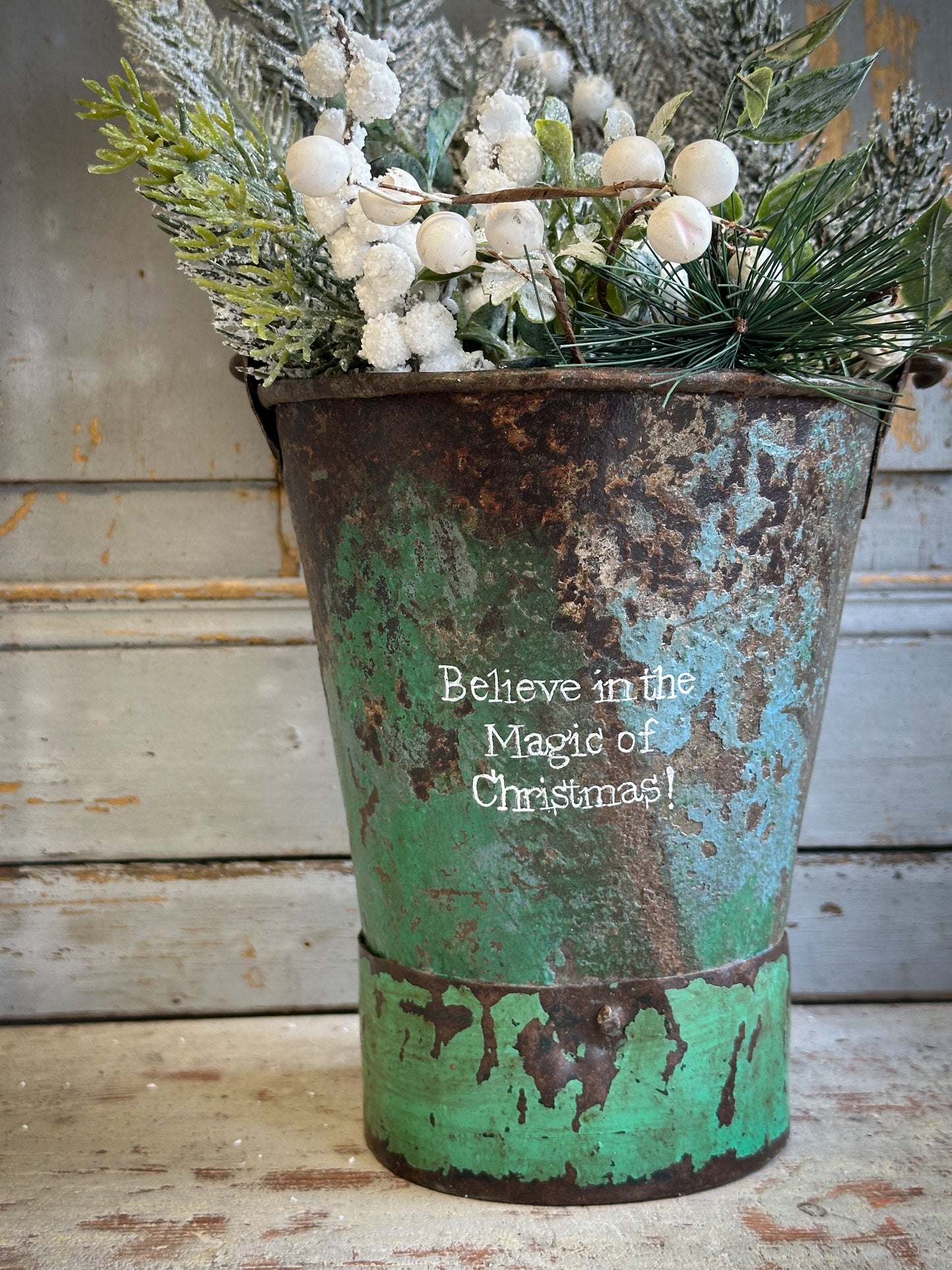A Recycled Metal Mini Christmas Tree Bucket With A Hand Painted Quote
