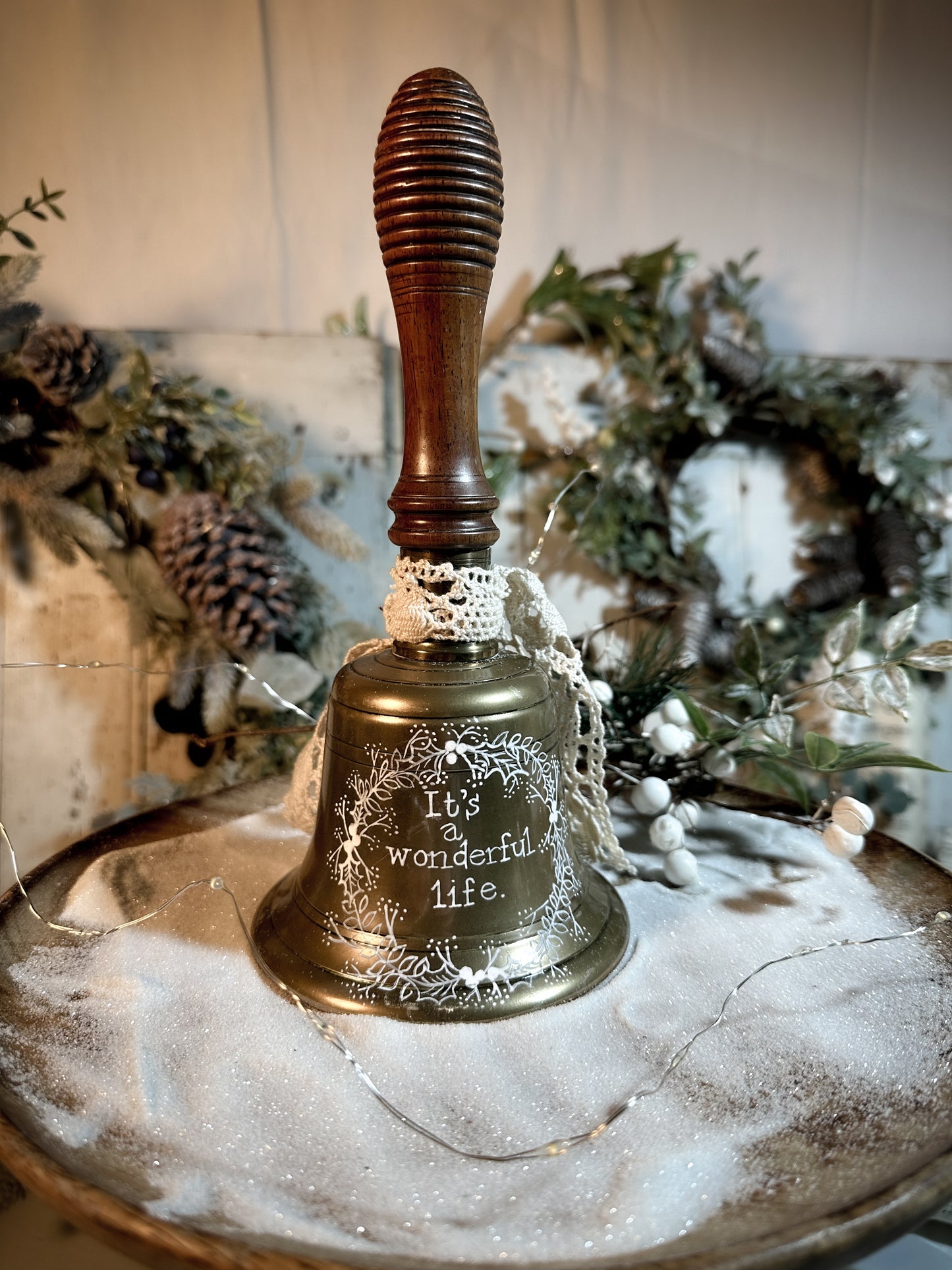 A vintage brass hand held bell with a hand painted quote