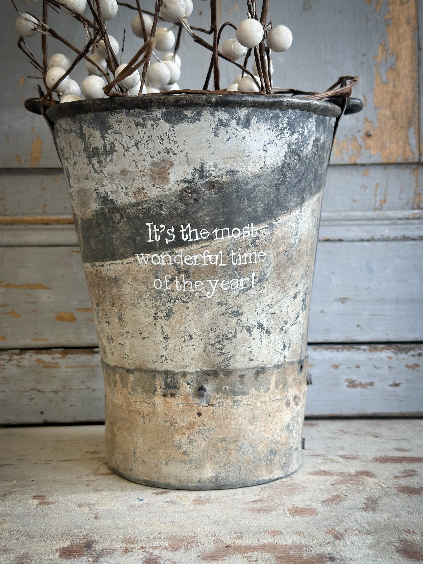 A Recycled Metal Mini Christmas Tree Bucket With A Hand Painted Quote