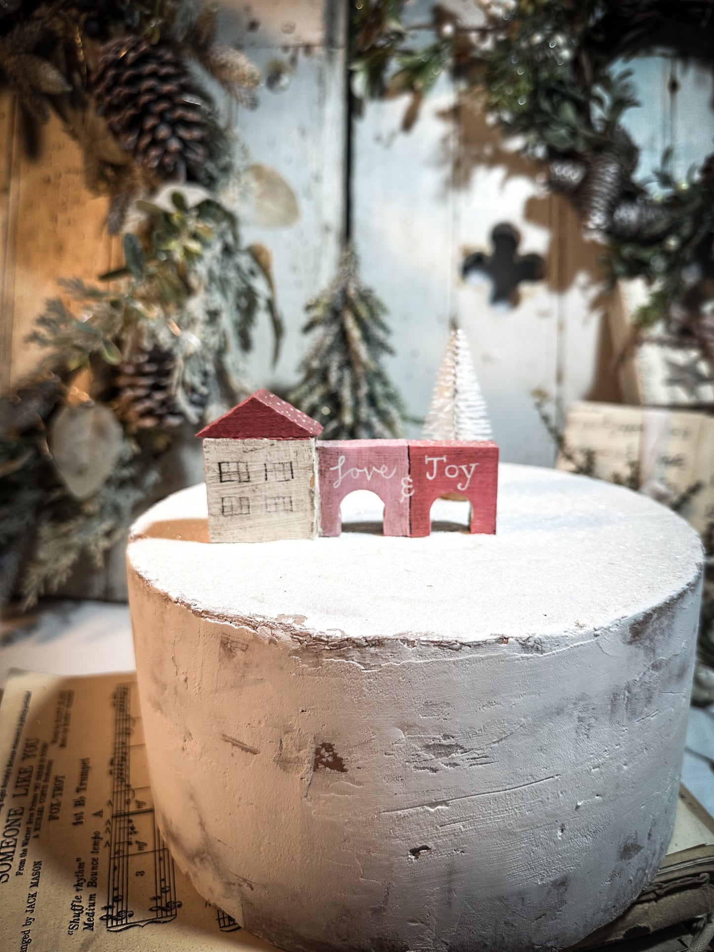 A pretty vintage German Erzgebirge Putz wooden village house painted with a Christmas quote