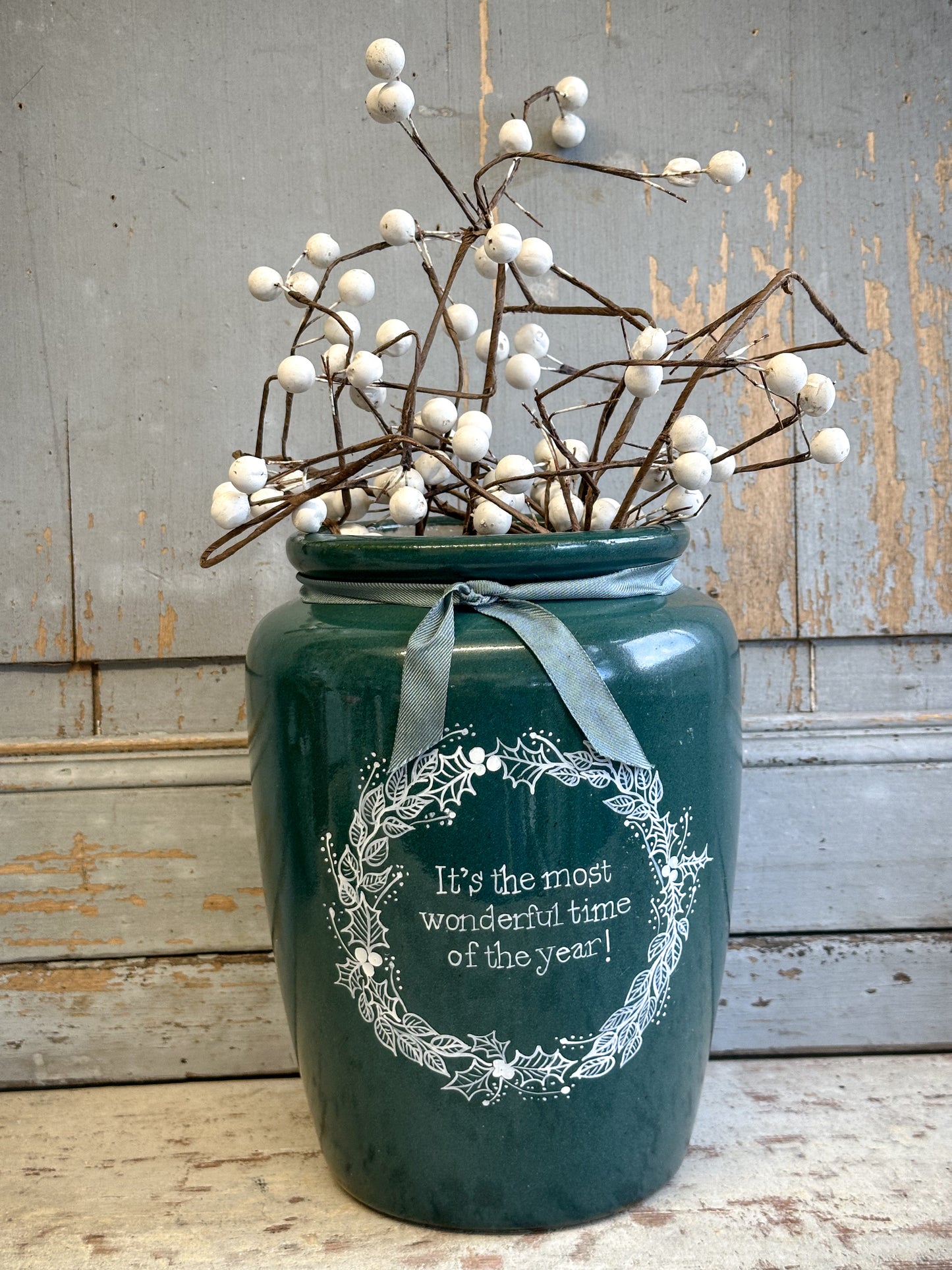 A large Emerald Green Antique Creamery Vase Bottle with a Hand Painted Wreath and Christmas Quote