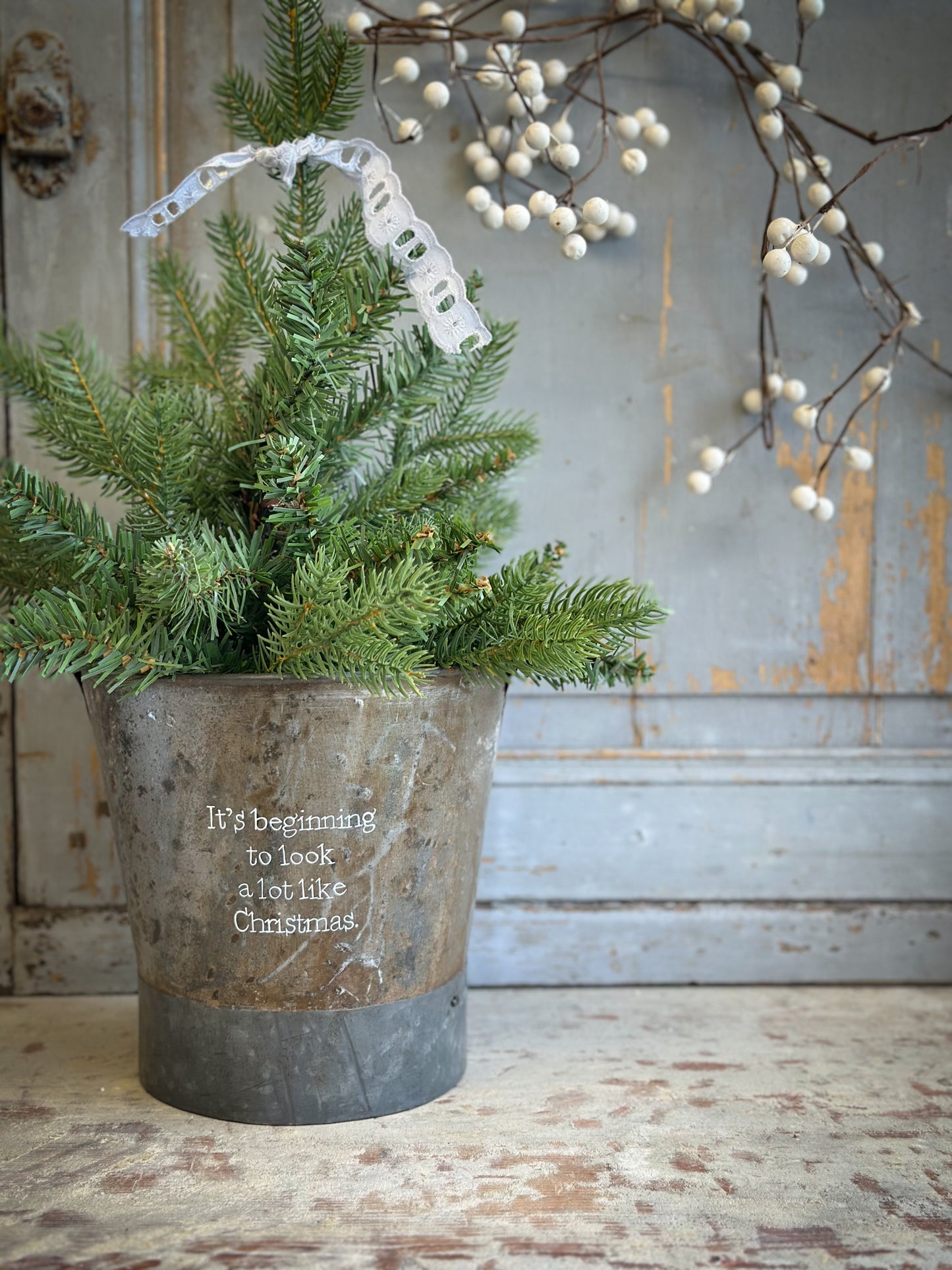 A Recycled Metal Small Christmas Tree Bucket With A Hand Painted Quote