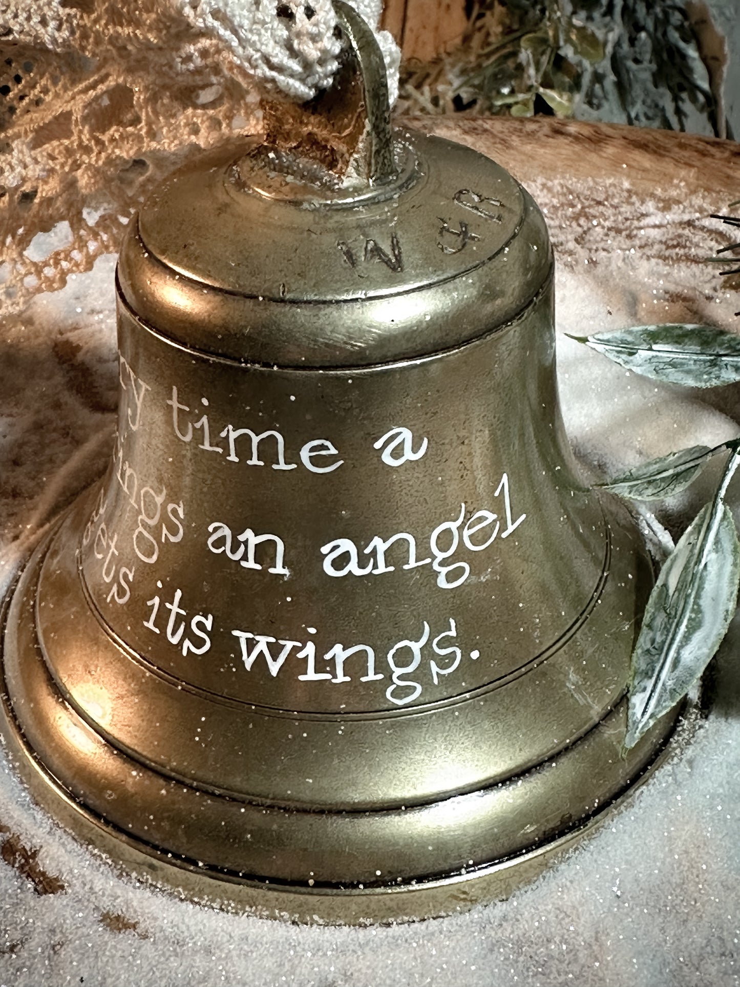 A vintage brass bell with a hand painted quote