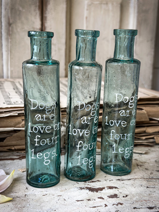 A beautiful Victorian cylinder bottle painted with a quote “Dogs are love on four legs”