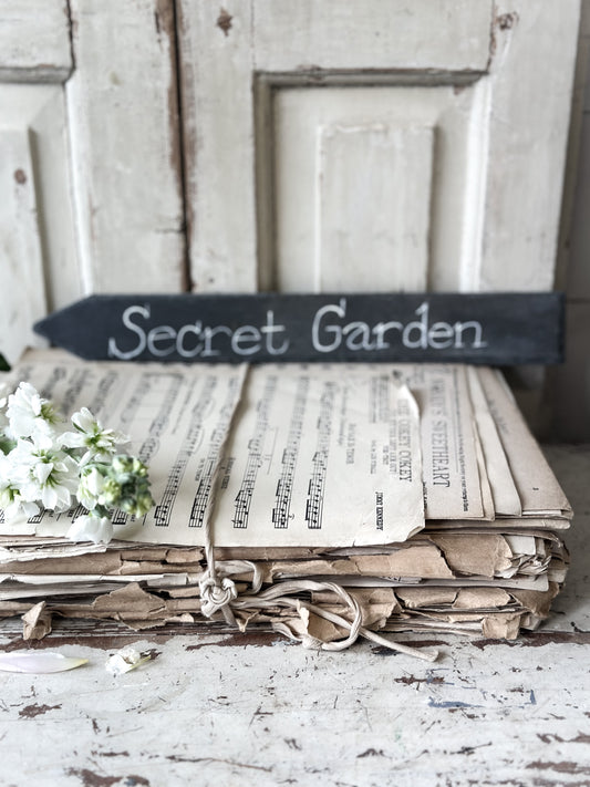 A large hand painted Victorian Welsh slate sign in lower case “Secret Garden”