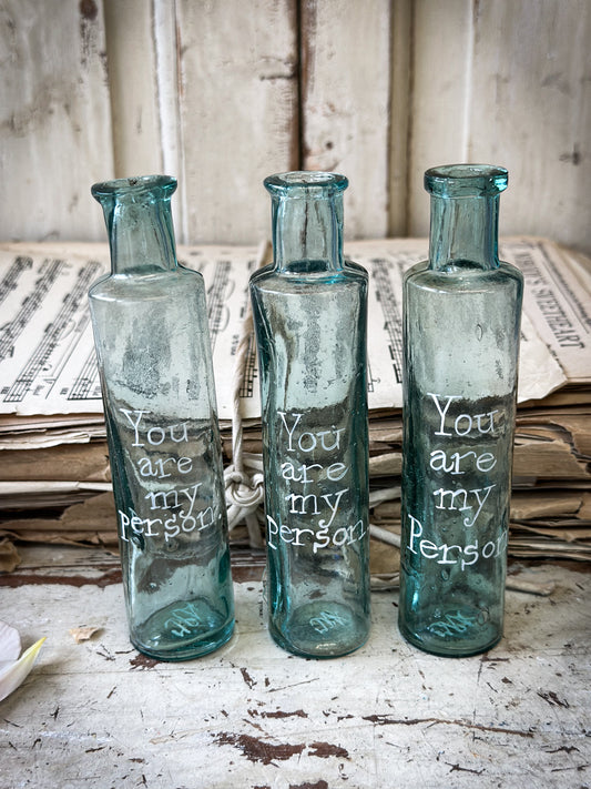 A beautiful Victorian cylinder bottle painted with a quote “You are my person”