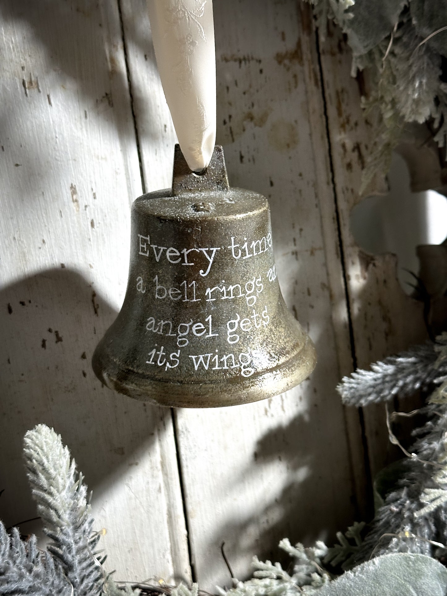 A vintage brass bell with a hand painted quote