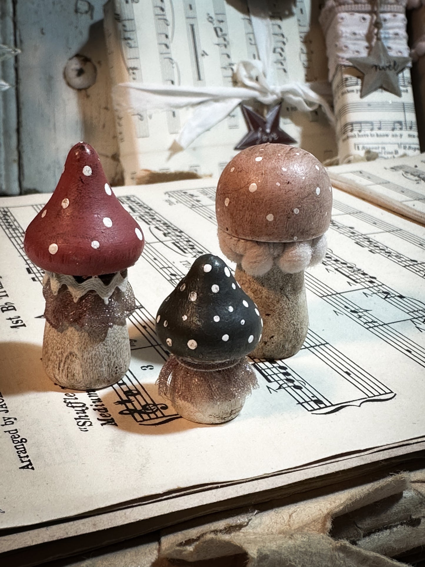 A set of three wooden hand painted and trimmed Christmas village toadstools