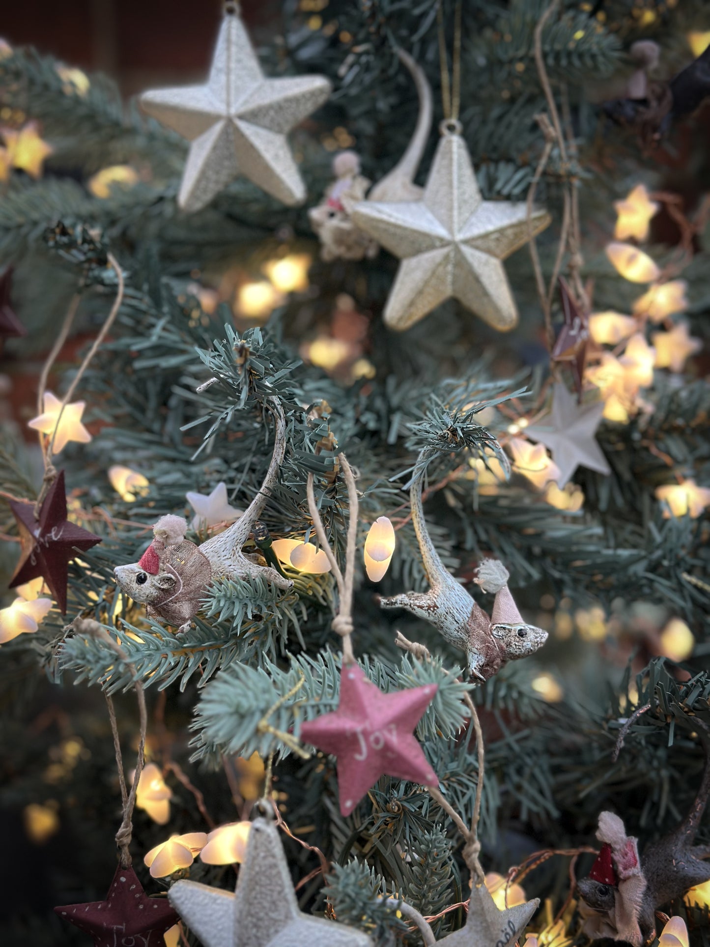 A mini tin barn star pink decoration hand painted with “Joy”