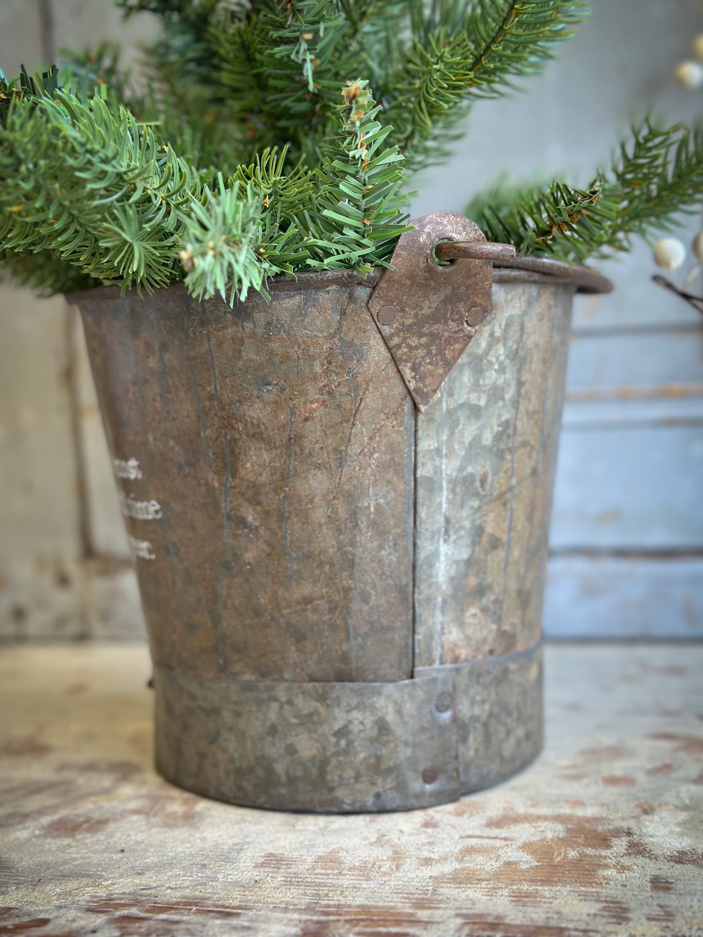 A Recycled Metal Small Christmas Tree Bucket With A Hand Painted Quote