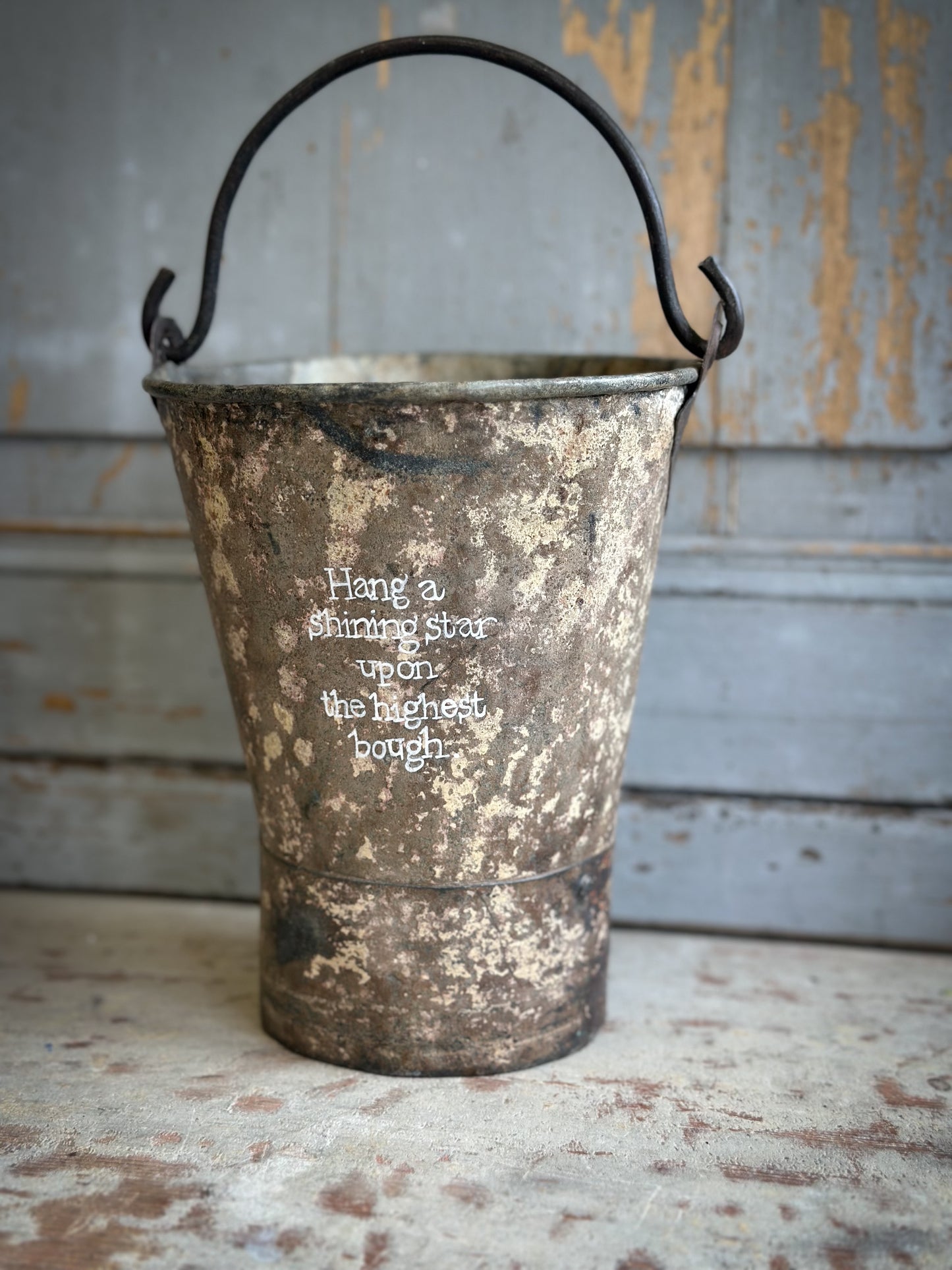A Recycled Metal Mini Christmas Tree Bucket With A Hand Painted Quote