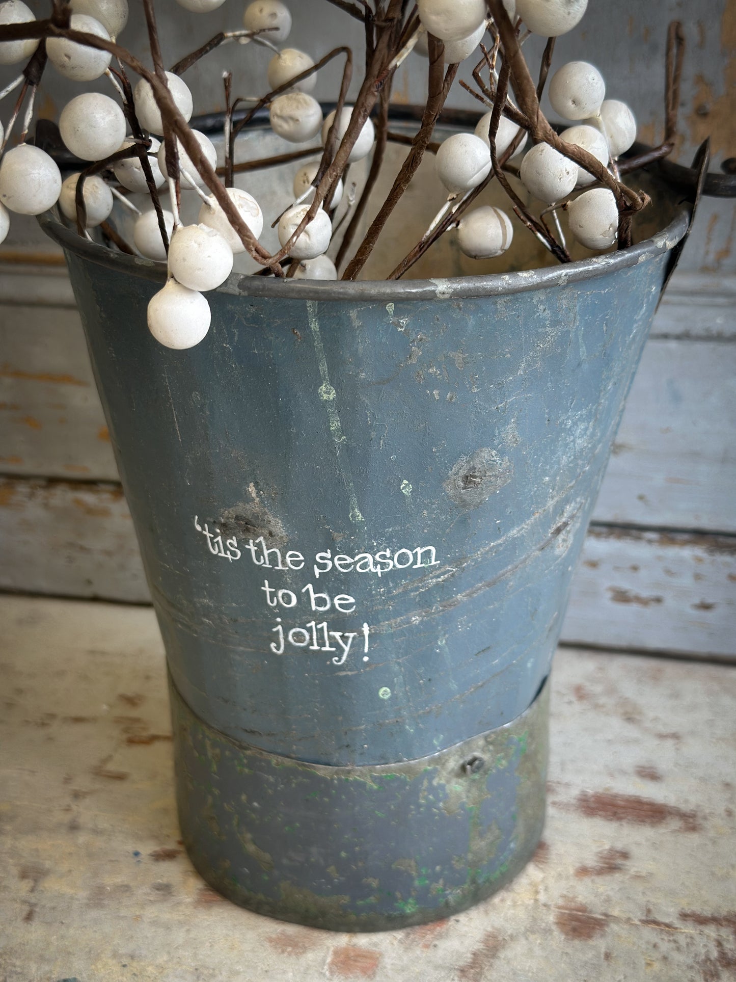 A Recycled Metal Mini Christmas Tree Bucket With A Hand Painted Quote