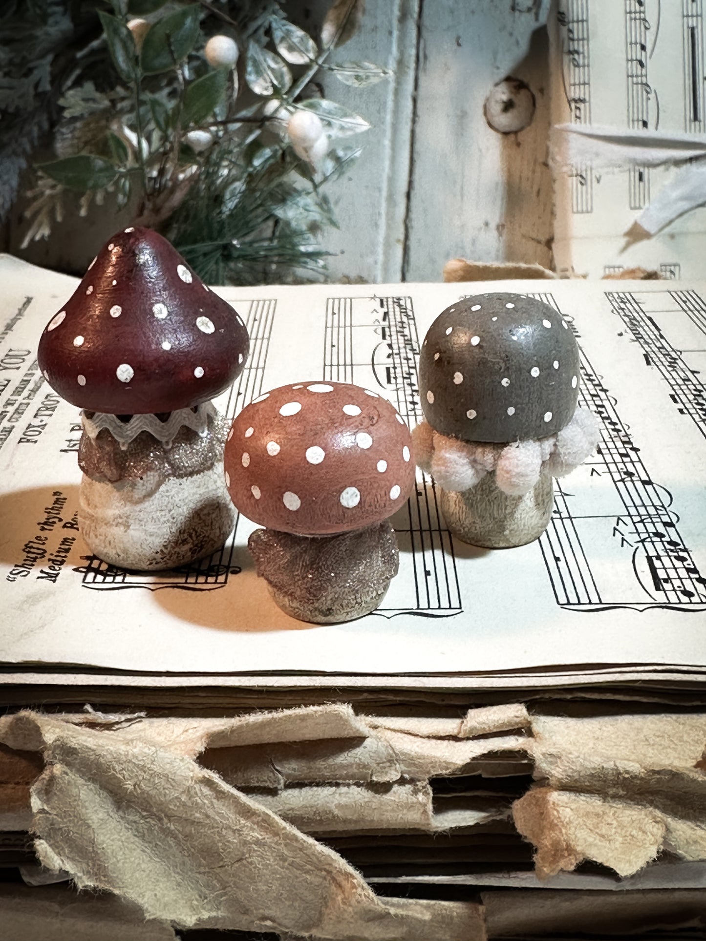 A set of three wooden hand painted and trimmed Christmas village toadstools