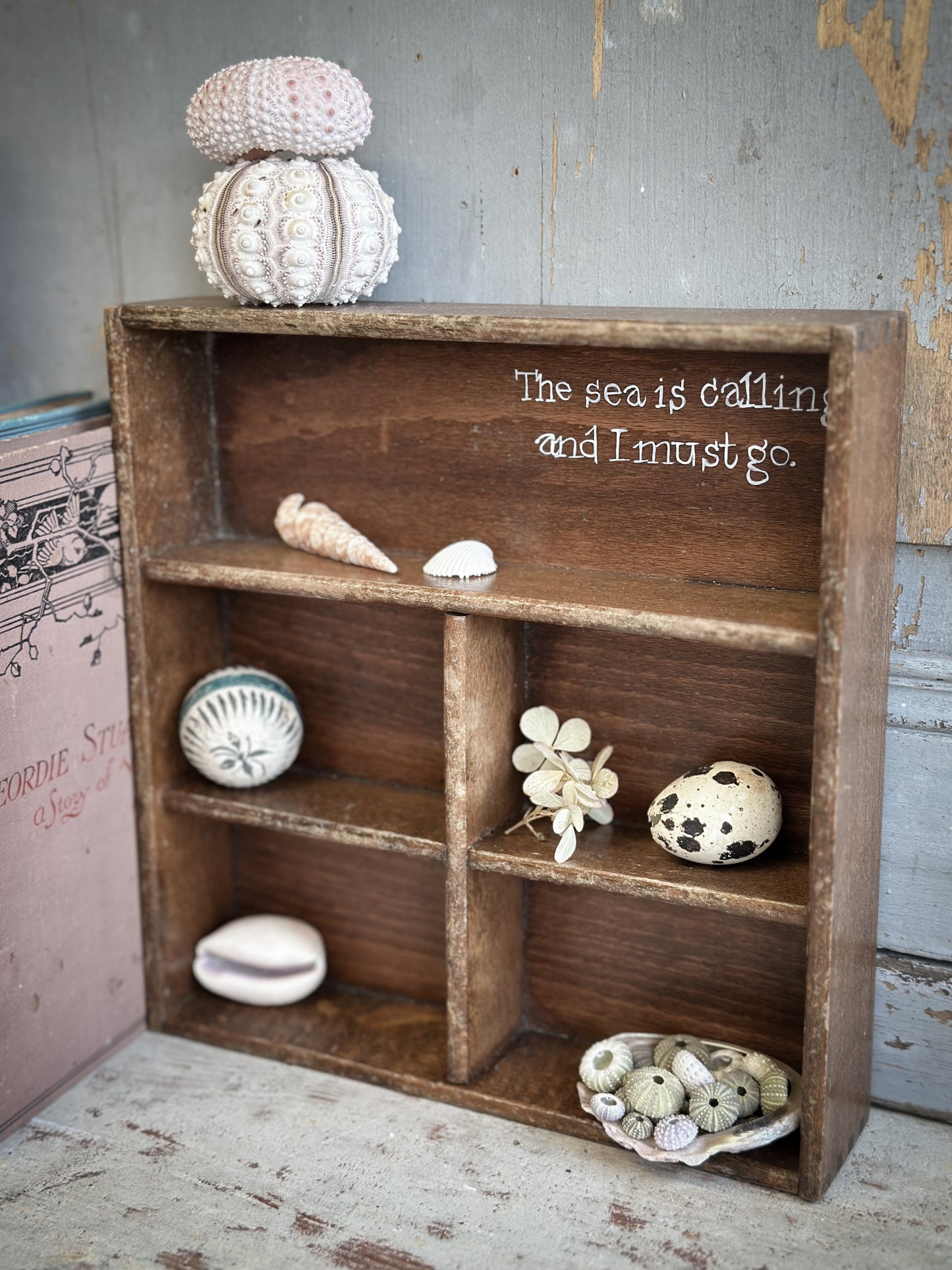 A Vintage Wooden Display Shelf With Hand Painted Quote