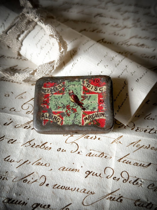 A rare English gramophone needle tin with bird on a green cross