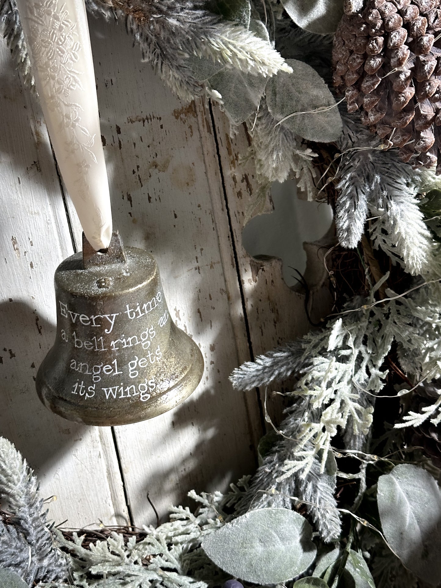 A vintage brass bell with a hand painted quote