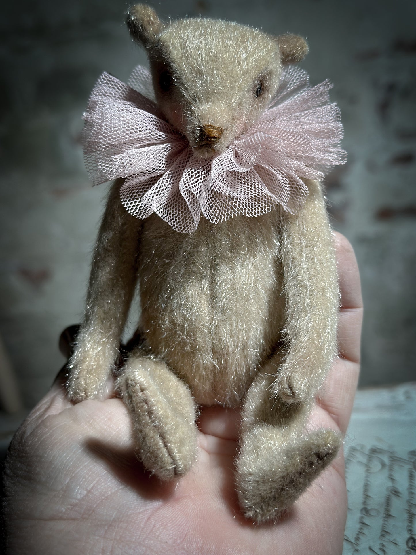 A beautiful hand made jointed collector’s teddy bear with antique pink tulle ruffle