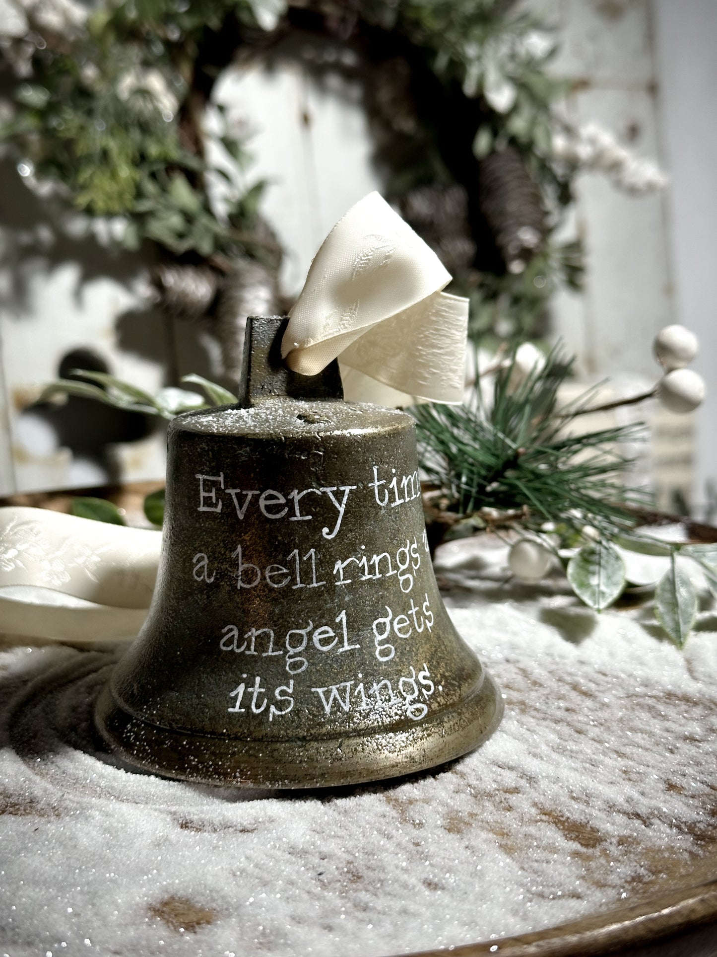 A vintage brass bell with a hand painted quote