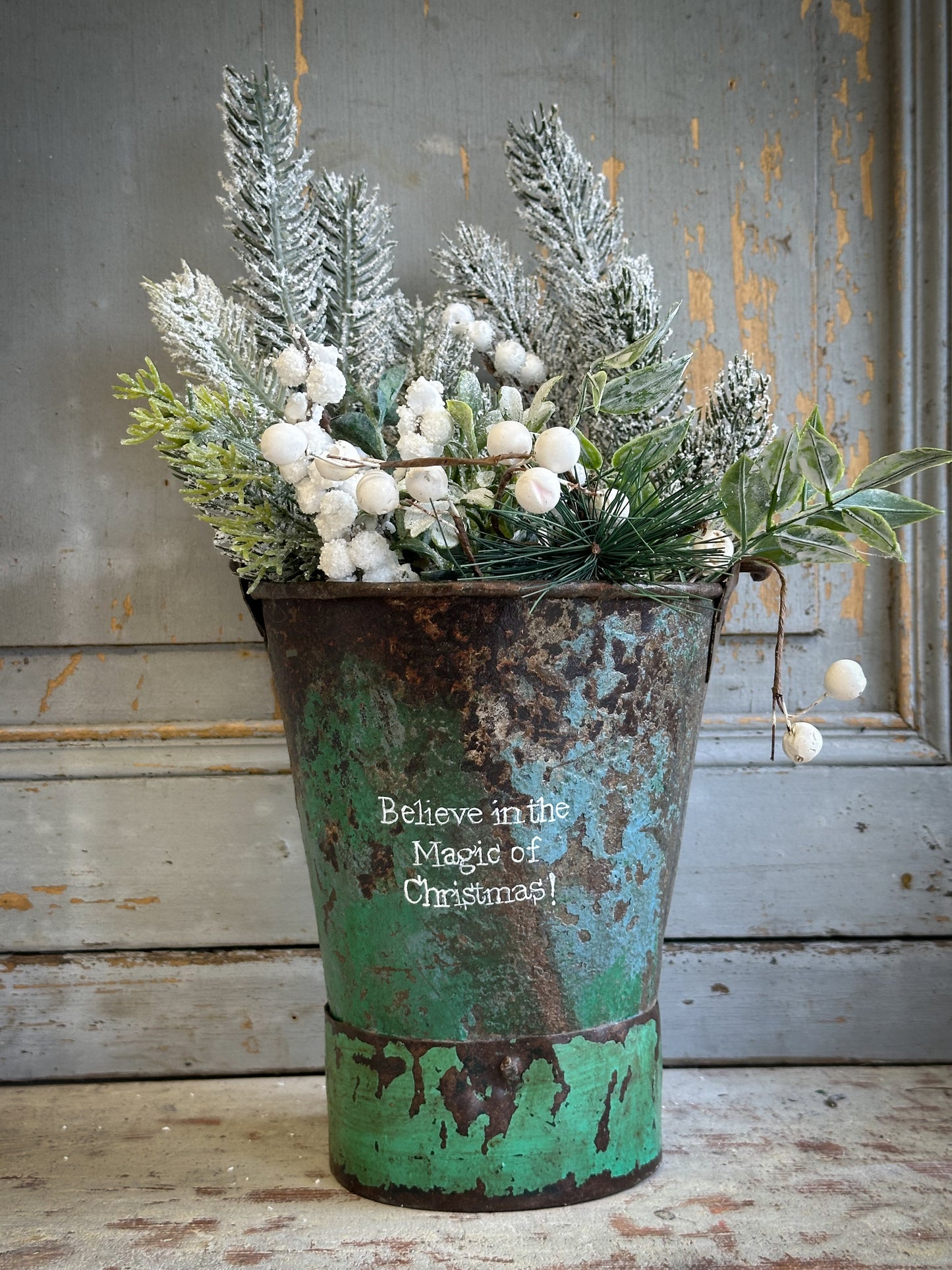 A Recycled Metal Mini Christmas Tree Bucket With A Hand Painted Quote