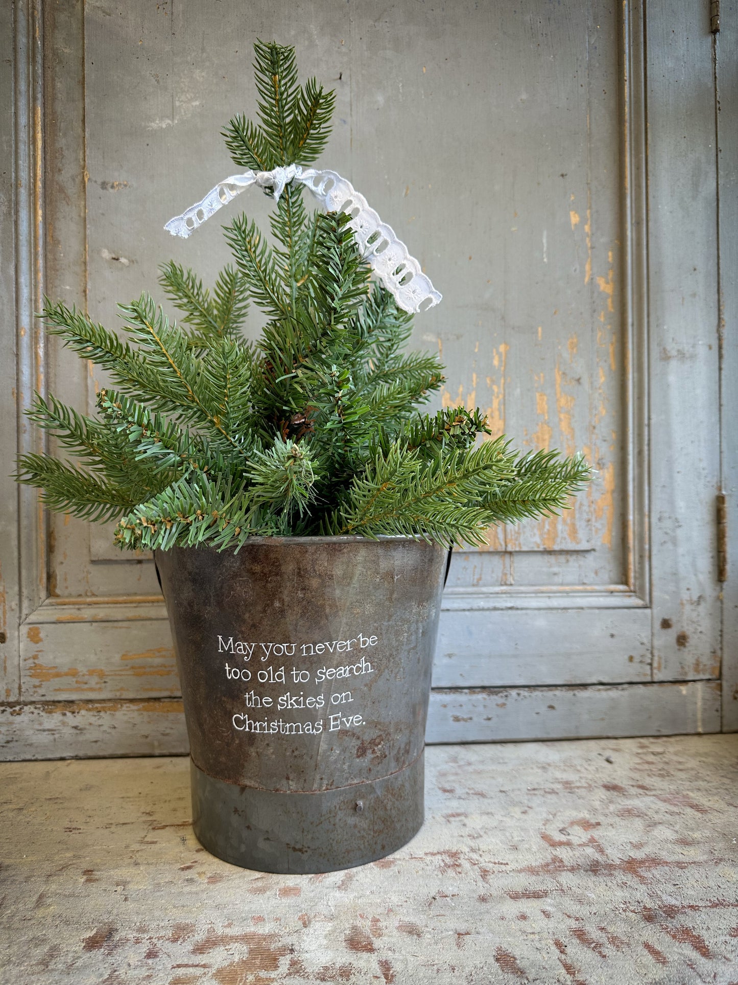 A Recycled Metal Small Christmas Tree Bucket With A Hand Painted Quote