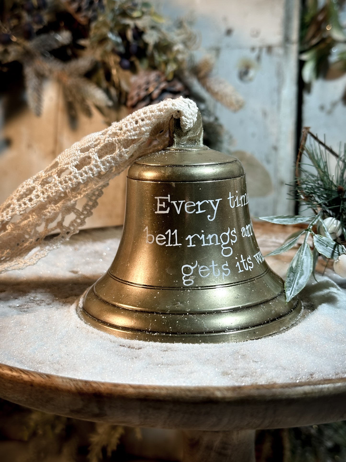 A vintage brass bell with a hand painted quote