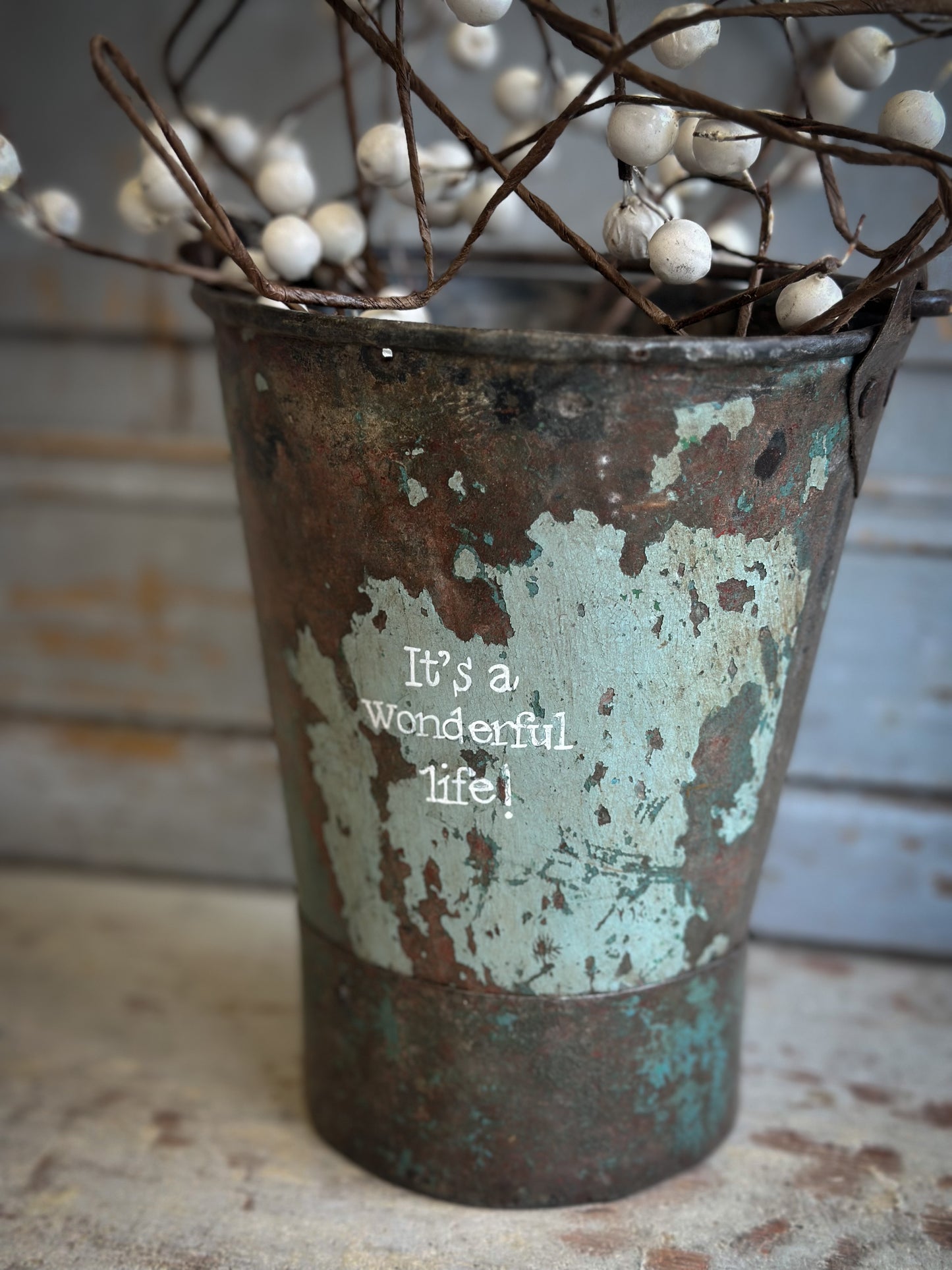A Recycled Metal Mini Christmas Tree Bucket With A Hand Painted Quote