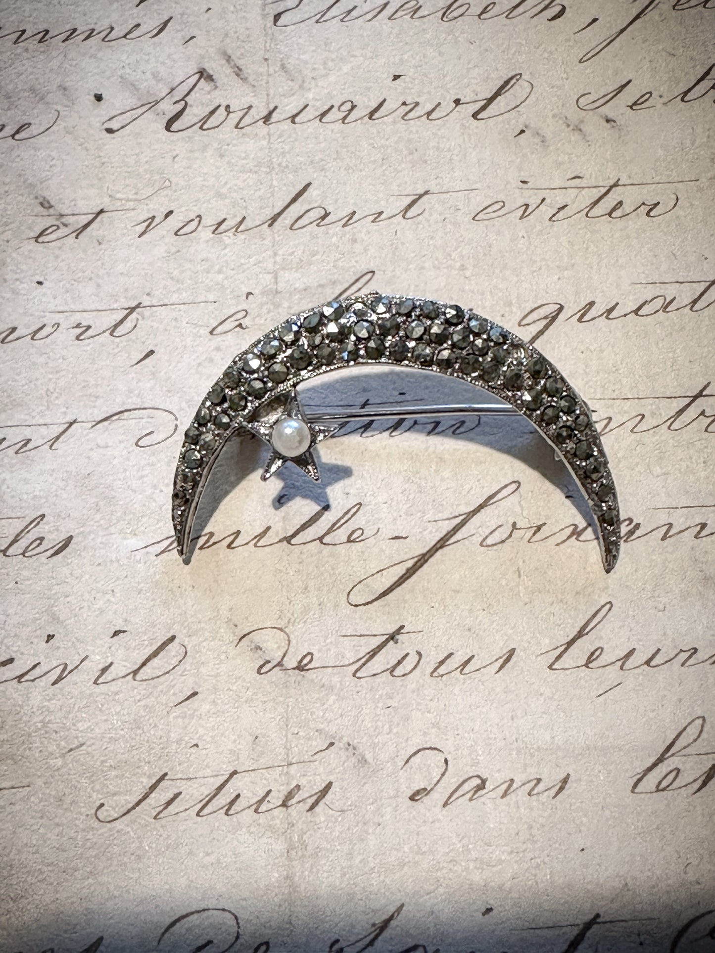 A stunning vintage marcasite and seed pearl crescent brooch