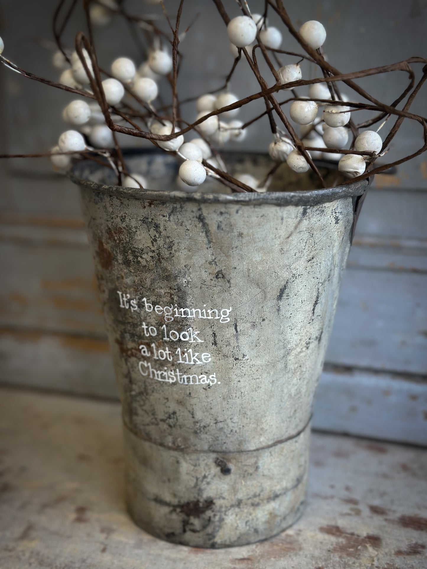 A Recycled Metal Mini Christmas Tree Bucket With A Hand Painted Quote