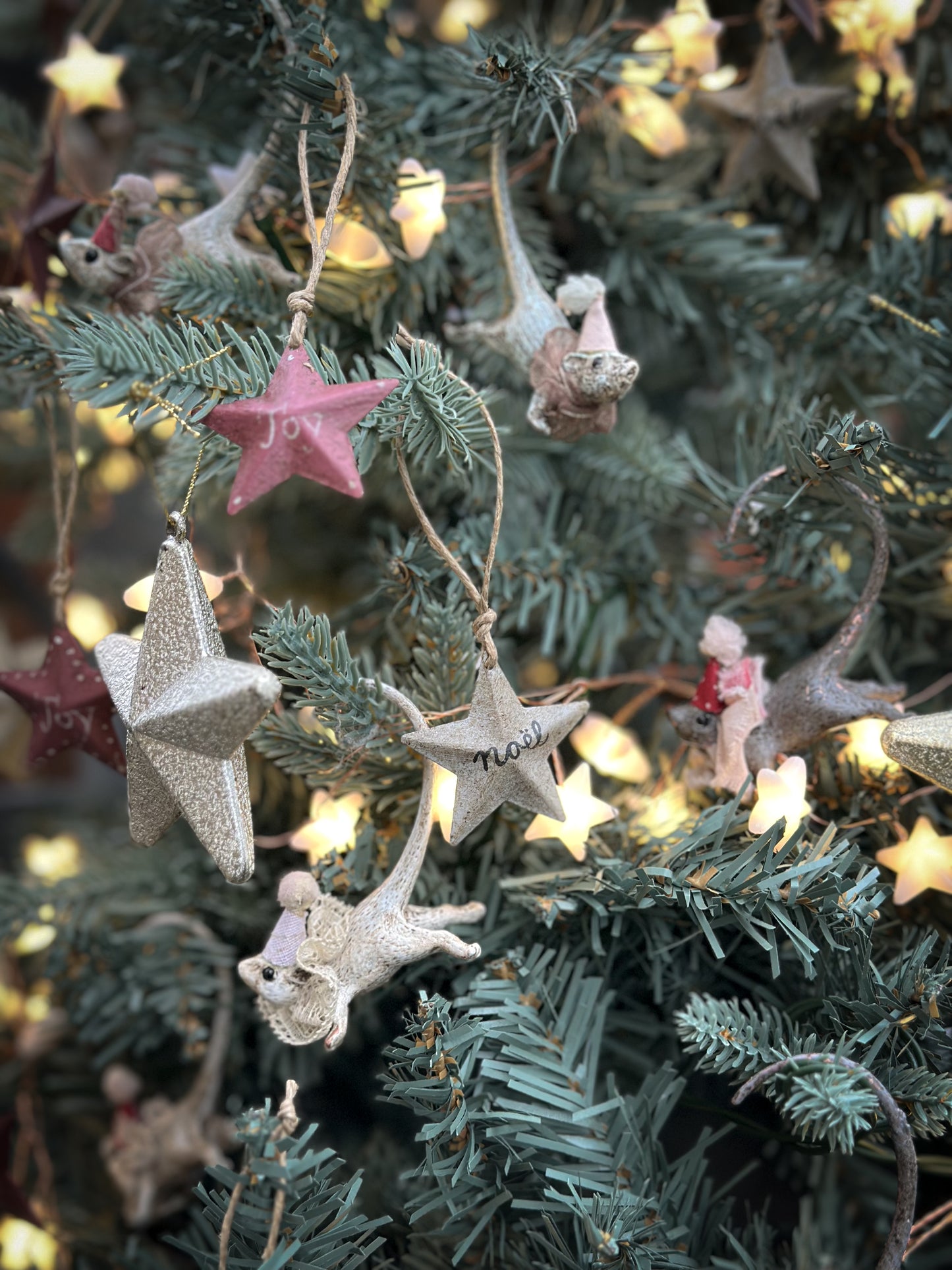 A mini tin barn star pink decoration hand painted with “Joy”